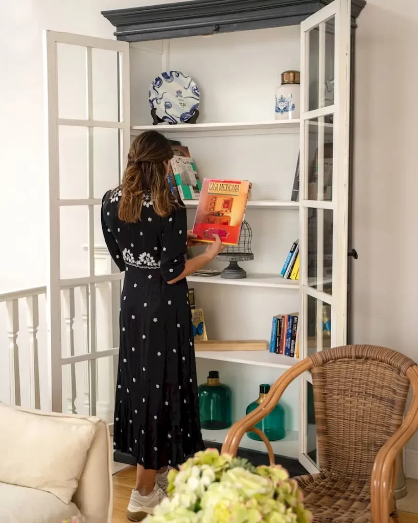 Guest browsing books in the cozy library area of Casa Goliana boutique hotel in Mexico City