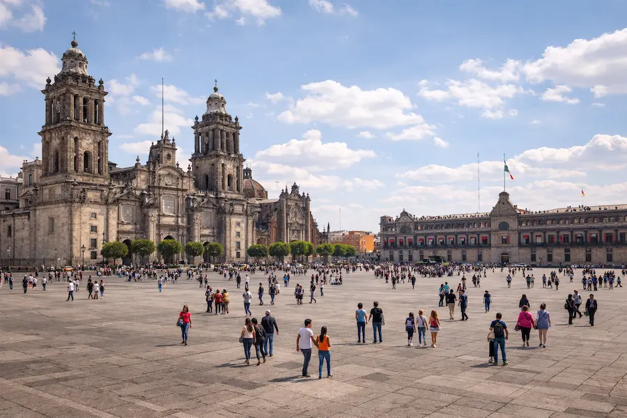 Zocalo in Mexico City with Metropolitan Cathedral and people exploring the historic center during the day