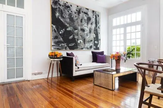 Elegant living room interior at Casa Goliana boutique hotel in Mexico City with modern art, wooden floors and luxury decor